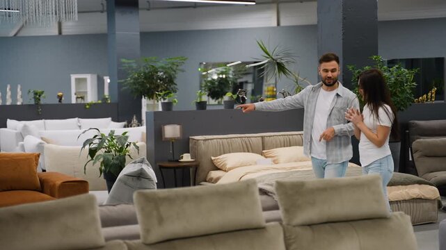 Young couple choosing new furniture in a store showroom