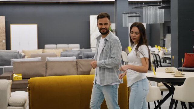 Young couple choosing furniture and sofas in a showroom