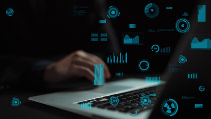 A close-up image of a person hands using a laptop, showcasing various digital data visualization elements and graphs overlaid on the screen in a dark setting. Xenic