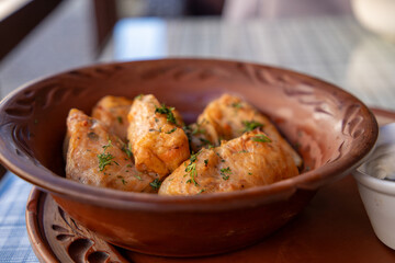 Stuffed cabbage leaves, cabbage rolls, and dolma in a clay pot, served with sour cream. Cabbage wraps. Chow Farsi, dolma, sarma, cabbage rolls, or golabki. Flat lay, arrangement, overhead.