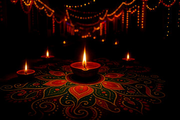 Diwali Festival Celebration: Capturing the spirit of Diwali, a meticulously crafted rangoli is illuminated by flickering clay lamps, against a backdrop of festive string lights in the darkness.