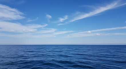 Obraz premium Vast blue ocean with gentle waves under a sky with scattered white clouds, horizon line, serene seascape