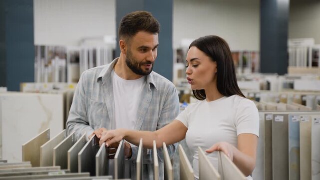 Young couple choosing discounted ceramic tiles in hardware store