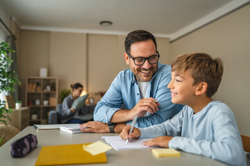 Obraz premium Father helping son with homework, teaching and learning at home
