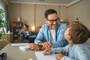 Obraz premium Father helping son with homework, teaching and learning at home