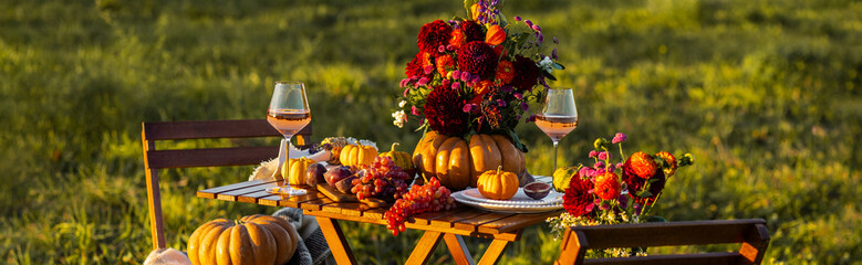 Banner. Fall table decoration with pumpkin composition. Family cozy thanksgiving dinner arrangement outdoors, in a garden, elegant wedding decor. Countryside style, rose wine, fruits, autumn mood