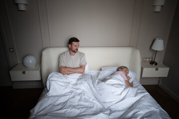 Man and woman emotionally distant in shared bed due to unresolved tension and intimacy issues at...