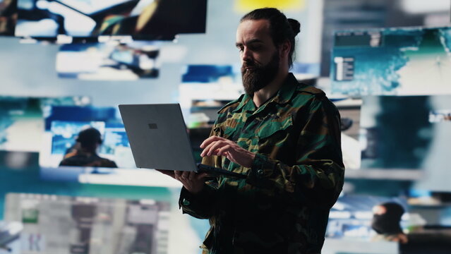 Armed forces soldier gathers surveillance from digital drone systems, preparing for combat with warfare strategies and battlefield details. War planning operations in command center. Camera A.