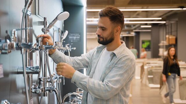 Man choosing new shower fixture in hardware store