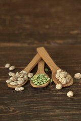 Rustic Still Life Of Pinto Beans, Green Pepitas, And Chickpeas On Wooden Spoons For Healthy Cooking