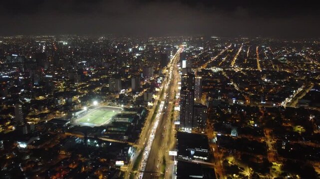 Brightly illuminated city landscape of lima, peru showing heavy traffic on javier prado avenue at