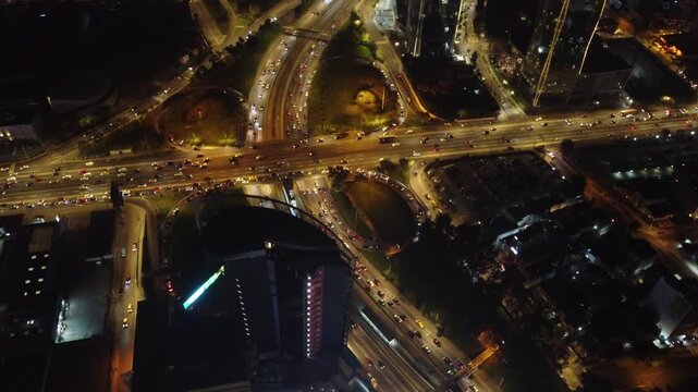 Aerial night view of the illuminated javier prado avenue interchange with heavy traffic flow in lima