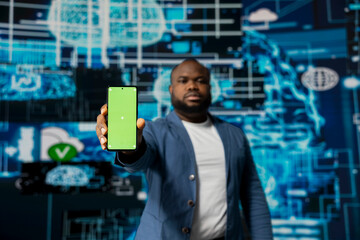 African american high tech strategist holding phone with isolated mockup display, analyzing predictive analytics and neural networks for virtual intelligence and platform innovation.