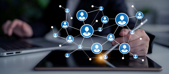 A business professional actively engaging in digital networking, illustrating user connections through icons on a tablet, showcasing modern collaboration in the workplace. Tessel