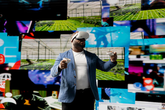 African american media user immersed in visual environment with VR headset, representing communication, e commerce and online entertainment. Social networking powered by digital tools. - Powered by Adobe