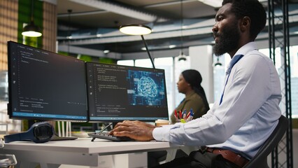 Fototapeta premium System administrator at office desk developing software applications using AI automation. IT specialist working on computer, debugging applications with artificial intelligence, camera A