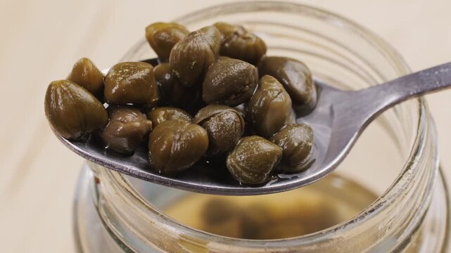 Pickled capers spanish food. Marinated buds of caper bush. Mediterranean cuisine ingredient. Organic spices and seasonings for meat, fish and vegetables, macro shot. Top view.