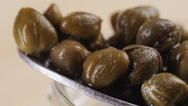 Pickled capers spanish food. Marinated buds of caper bush. Mediterranean cuisine ingredient. Organic spices and seasonings for meat, fish and vegetables, macro shot. Top view.