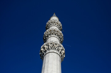 Minaret next to a mosque. Airplane flying over the minaret. Mosque in Ankara, Turkey.