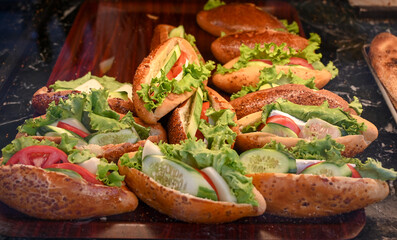 A delicious sandwich in the window. Sandwiches in fast food. Sandwich with salami and vegetables.