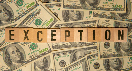 Wooden blocks with EXCEPTION text of concept, pens, notebooks, and books