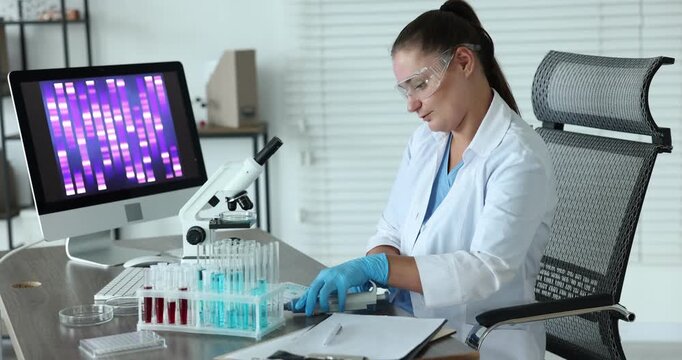 Research in genetics. Scientist working with microscope at table in laboratory