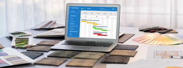 Obraz premium Interior designer workspace table and architecture software on laptop screen with mood board materials and colorful swatch color for color selection. Modern interior design office. Insight