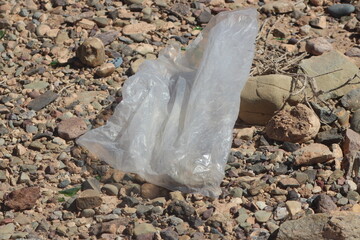 A close up of a transparent plastic bag lying on the ground