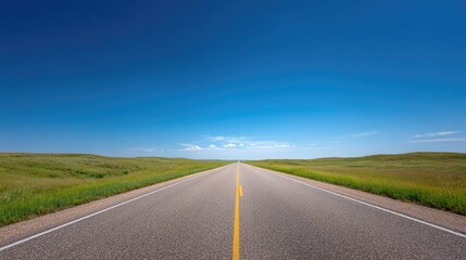 Fototapeta premium Majestic Open Road Stretching Towards a Bright Horizon with Clear Blue Sky and Lush Green Surroundings Under a Sunny Day