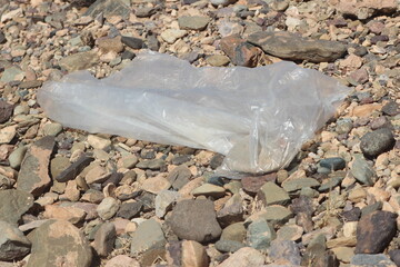 A close up of a transparent plastic bag lying on the ground