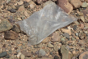 A close up of a transparent plastic bag lying on the ground