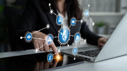 A businesswoman interacts with modern digital technology, surrounded by virtual icons that...