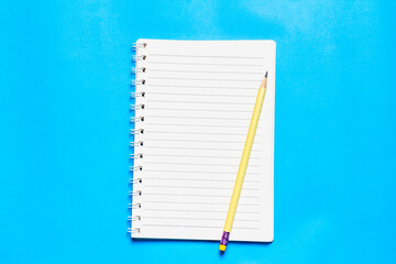 Empty notebook arranged on blue background.