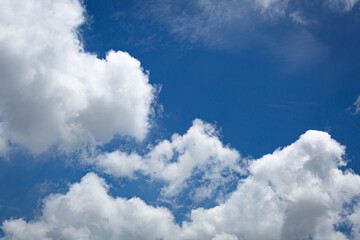 Clear blue sky with soft white clouds forming a peaceful and refreshing nature background,