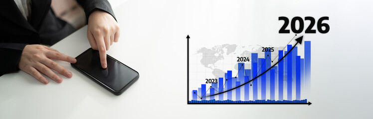 A businessman interacts with a smartphone while analyzing a growth chart depicting trends from 2023 to 2026, symbolizing future business projections and progress. Tessel