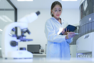 A laboratory manager reviews the entire workflow, using a tablet to analyze data from microscopy...