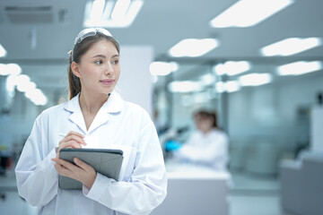 In a future 'smart lab,' a lead scientist uses her tablet as a command center, remotely monitoring IoT-connected instruments and analyzing real-time, AI-generated insights.