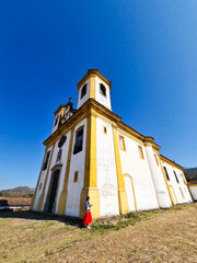 Woman leaning against the wall of the Church of Our Lady of Mercy, built in the 18th century in the city of Ouro Preto, Brazil