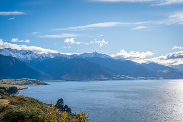 beautiful landscape view during road trip we can see yellow colorful leave trees along the turquoise lake with snow cap mountain range wanaka South Island New Zealand 