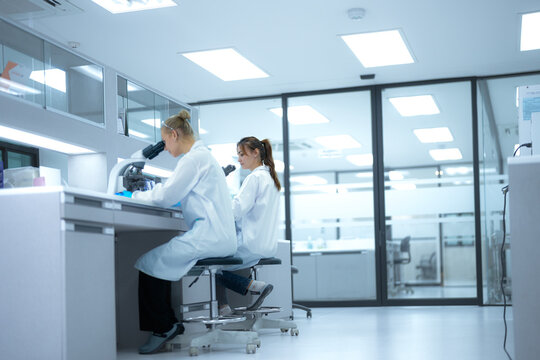 In a future 'open science' lab, researchers instantly upload microscopic findings to a global collaborative platform, receiving real-time peer feedback from a decentralized network of scientists.