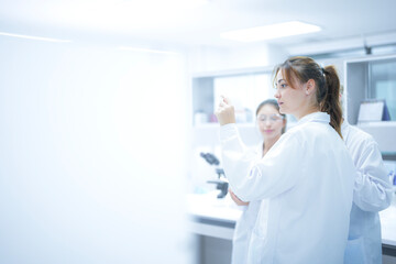 A scientist uses an augmented reality system to share a live microscopic view of a slide with remote colleagues, enabling real-time global consultation and AI-assisted analysis.