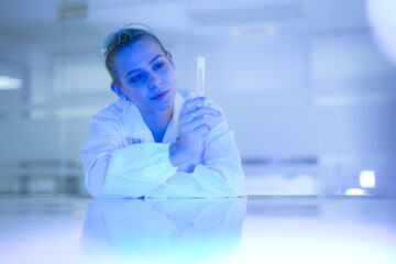 A bio-engineer in a futuristic lab examines a vial of glowing, synthetic cells, a product of advanced gene editing and bio-hacking, for use in next-generation therapeutics.