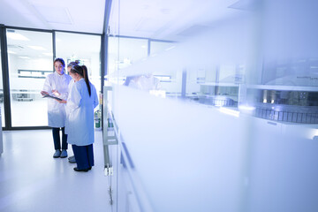 A bio-engineer in a futuristic lab examines a vial of glowing, synthetic cells, a product of advanced gene editing and bio-hacking, for use in next-generation therapeutics.