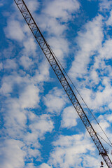 Against the backdrop of blue sky and white clouds, the working site of tower cranes at construction sites