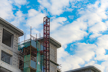 Against the backdrop of blue sky and white clouds, the working site of tower cranes at construction sites