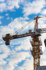 Against the backdrop of blue sky and white clouds, the working site of tower cranes at construction sites