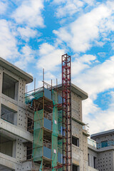 Against the backdrop of blue sky and white clouds, the working site of tower cranes at construction sites
