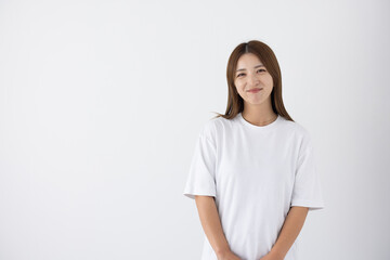 Fototapeta premium Smiling woman standing in front of white background