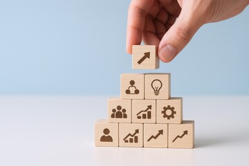 Building Business Success: Hand Stacking Wooden Blocks with Growth and Strategy Icons