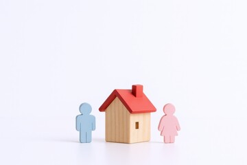Wooden figures representing a couple and their house, symbolizing homeownership, family, and security against a white backdrop
